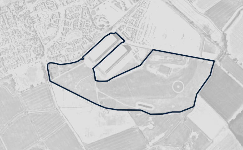 Greyscale aerial image of a plot of land, outlined in dark blue.