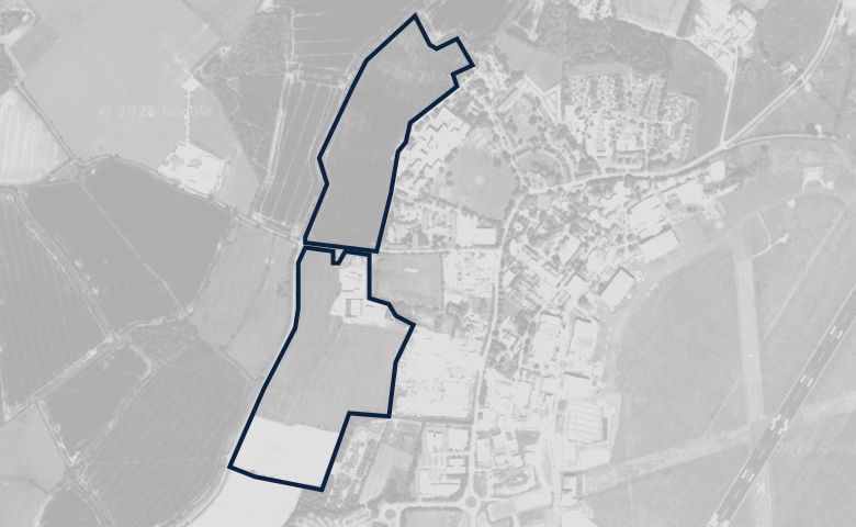 Greyscale aerial image of a plot of land, outlined in dark blue.