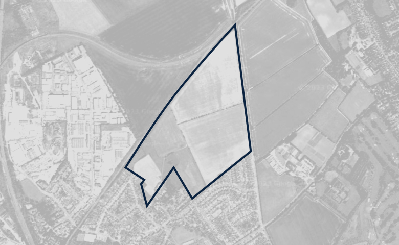 Greyscale aerial image of a plot of land, outlined in dark blue.