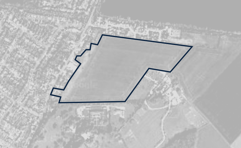 Greyscale aerial image of a plot of land, outlined in dark blue.